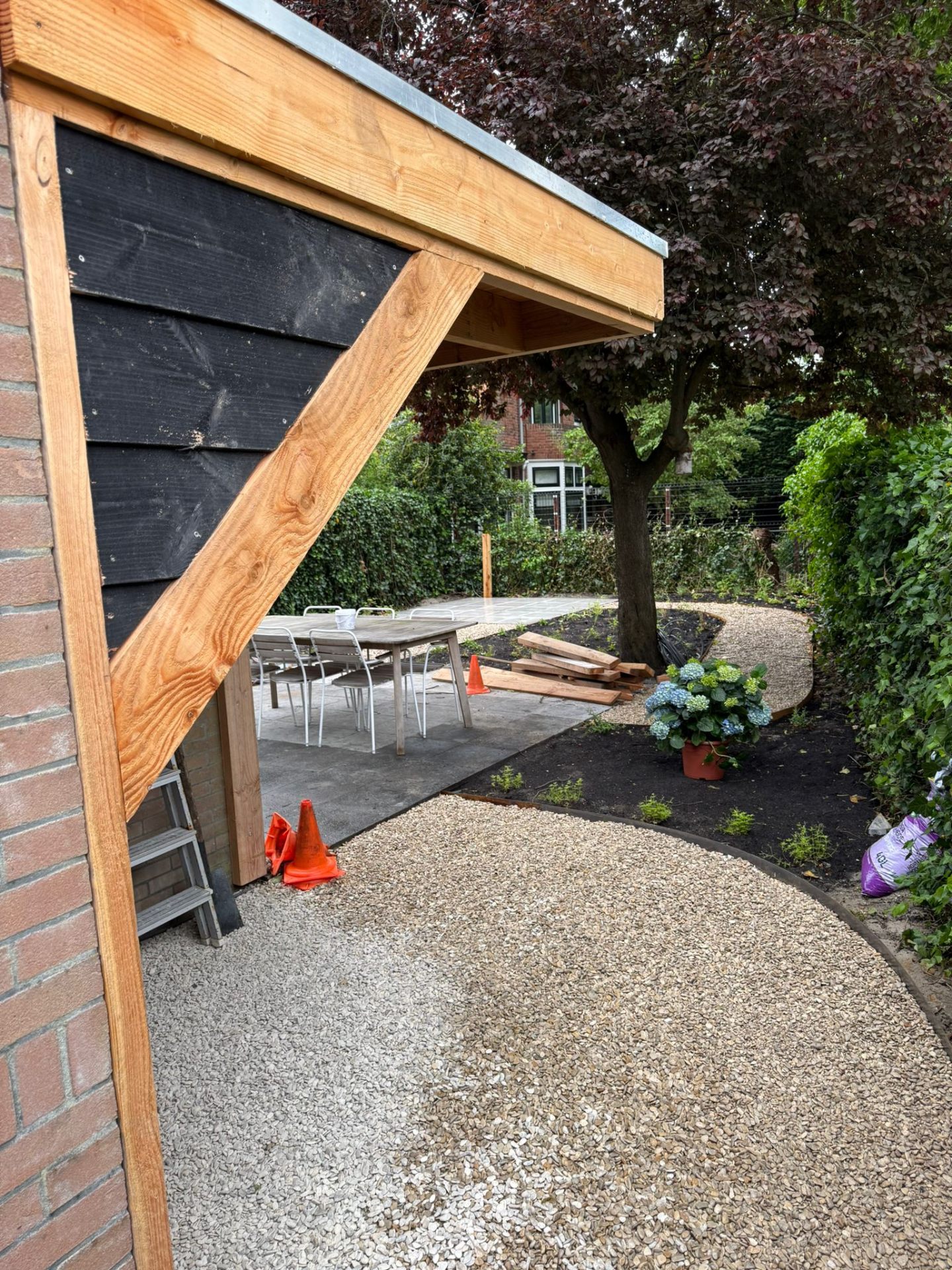Houten overkapping met split en hortensia's